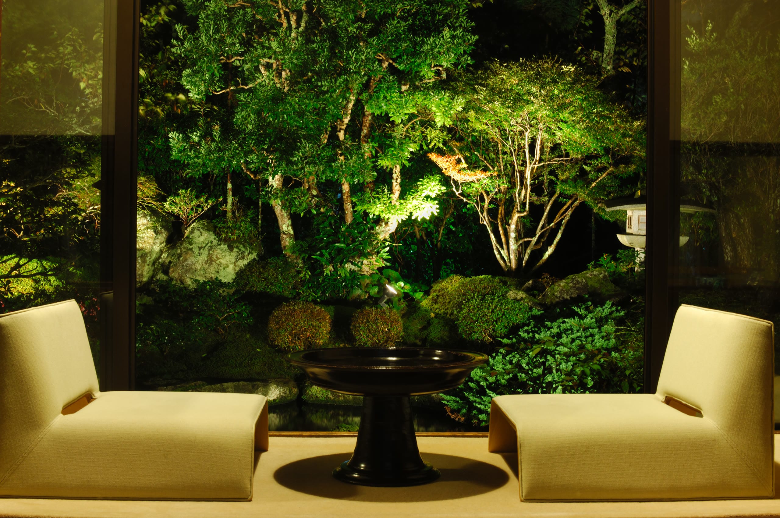 A ryokan lounge chair beside a window onto an autumn garden