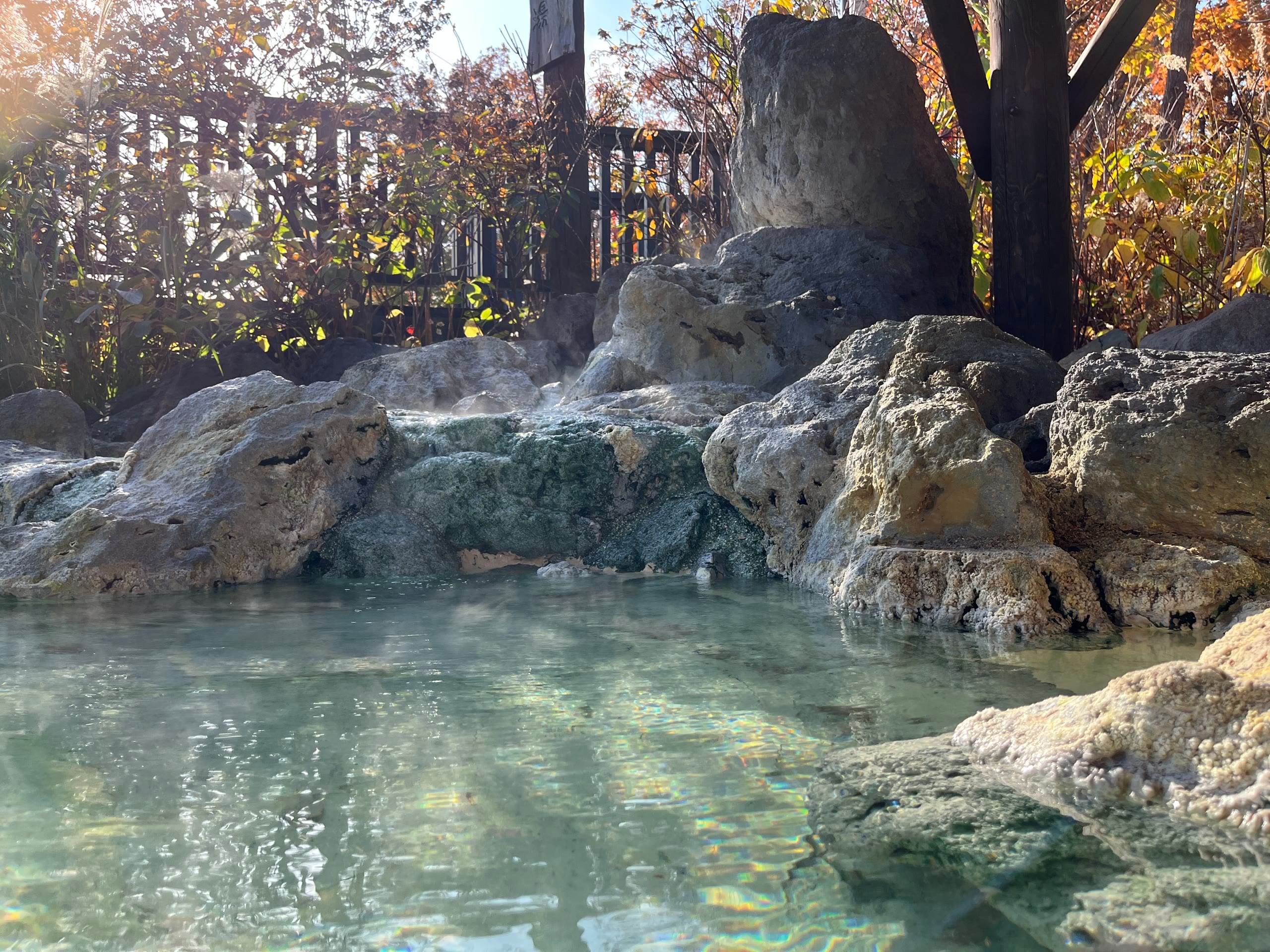 An open-air bath surrounded by autumn foliage in northern Japan