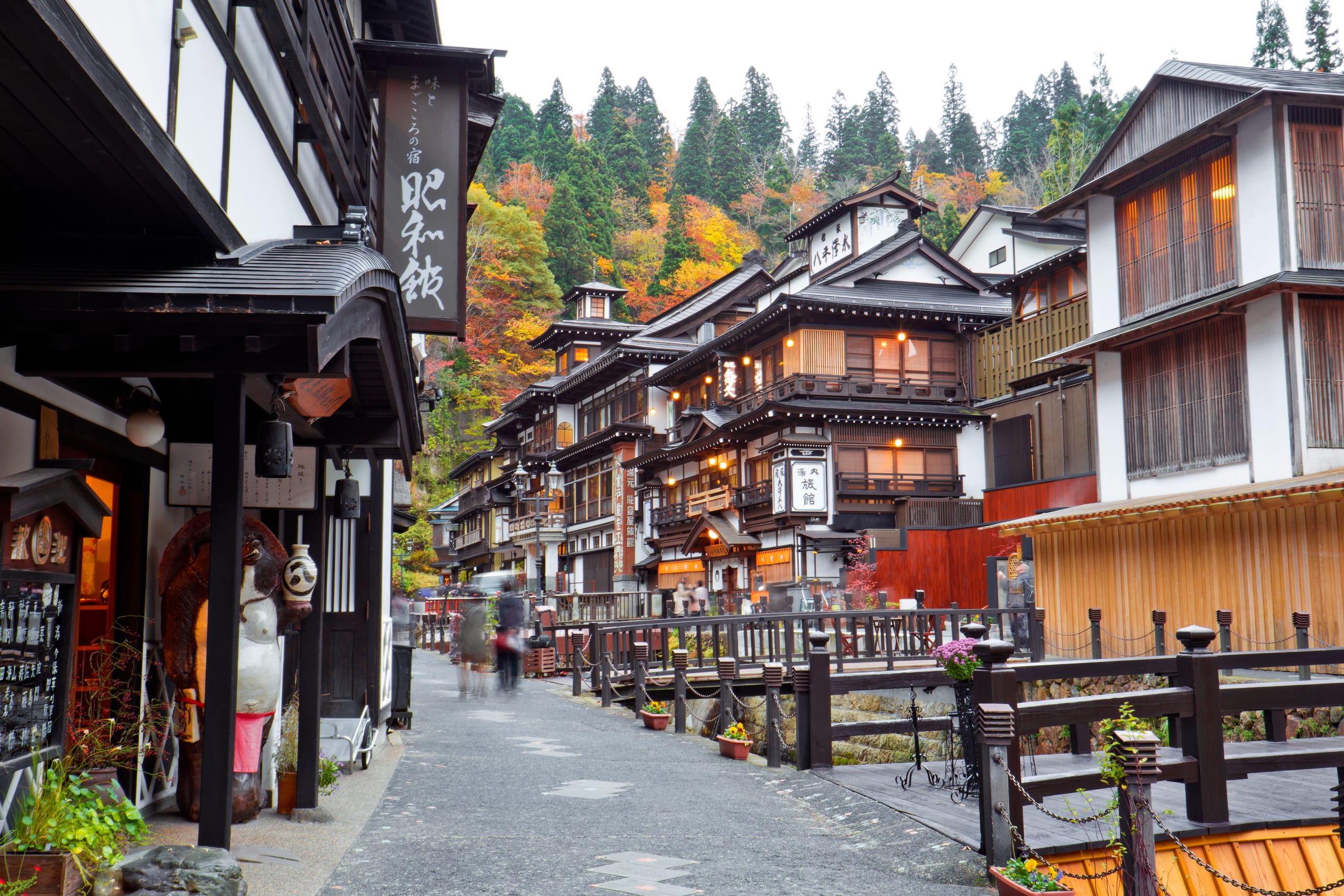 Ginzan Onsen's wooden inns lit by gas lamps over the river