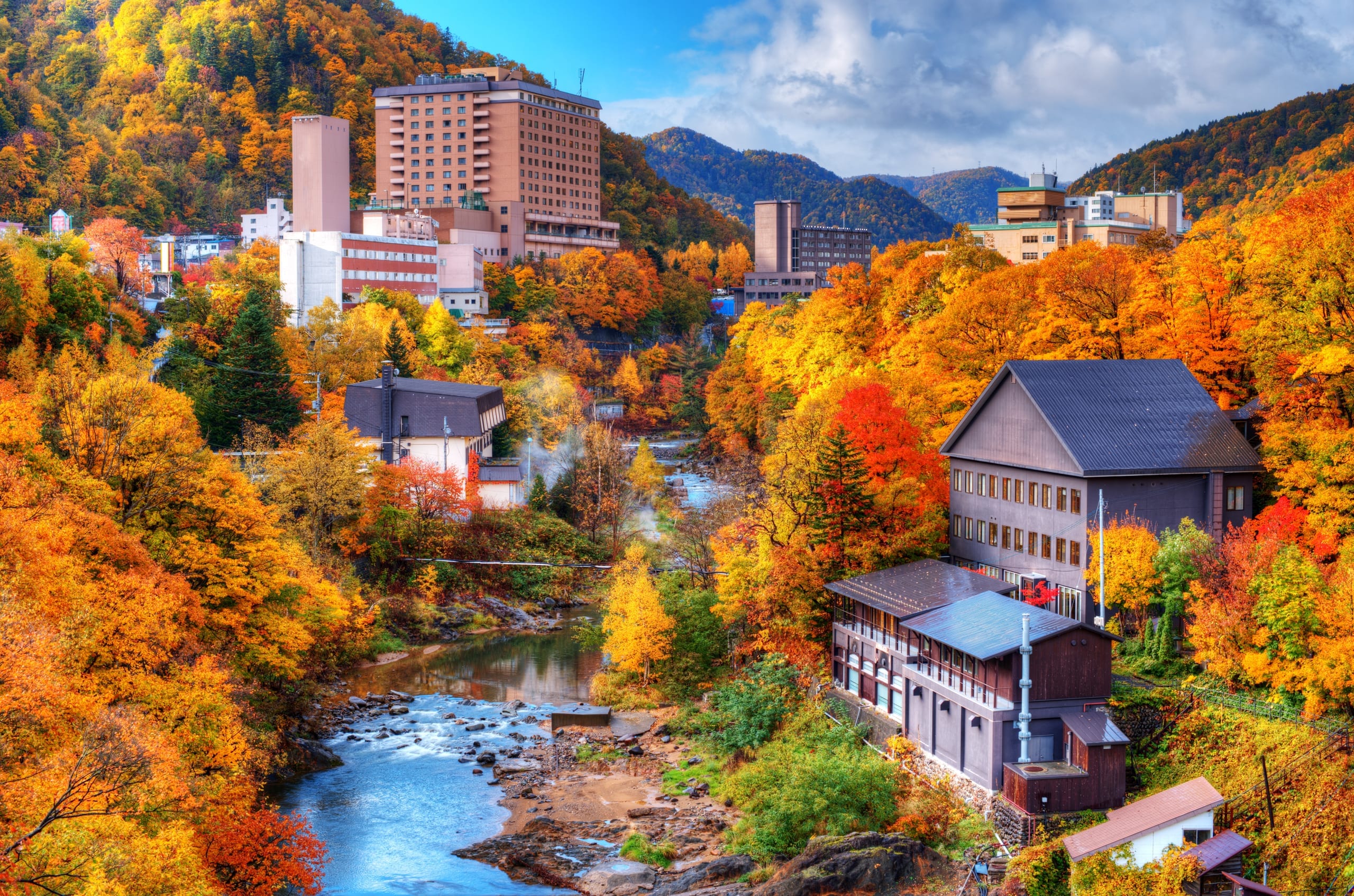 A hot-spring valley town in the mountains surrounded by autumn foliage