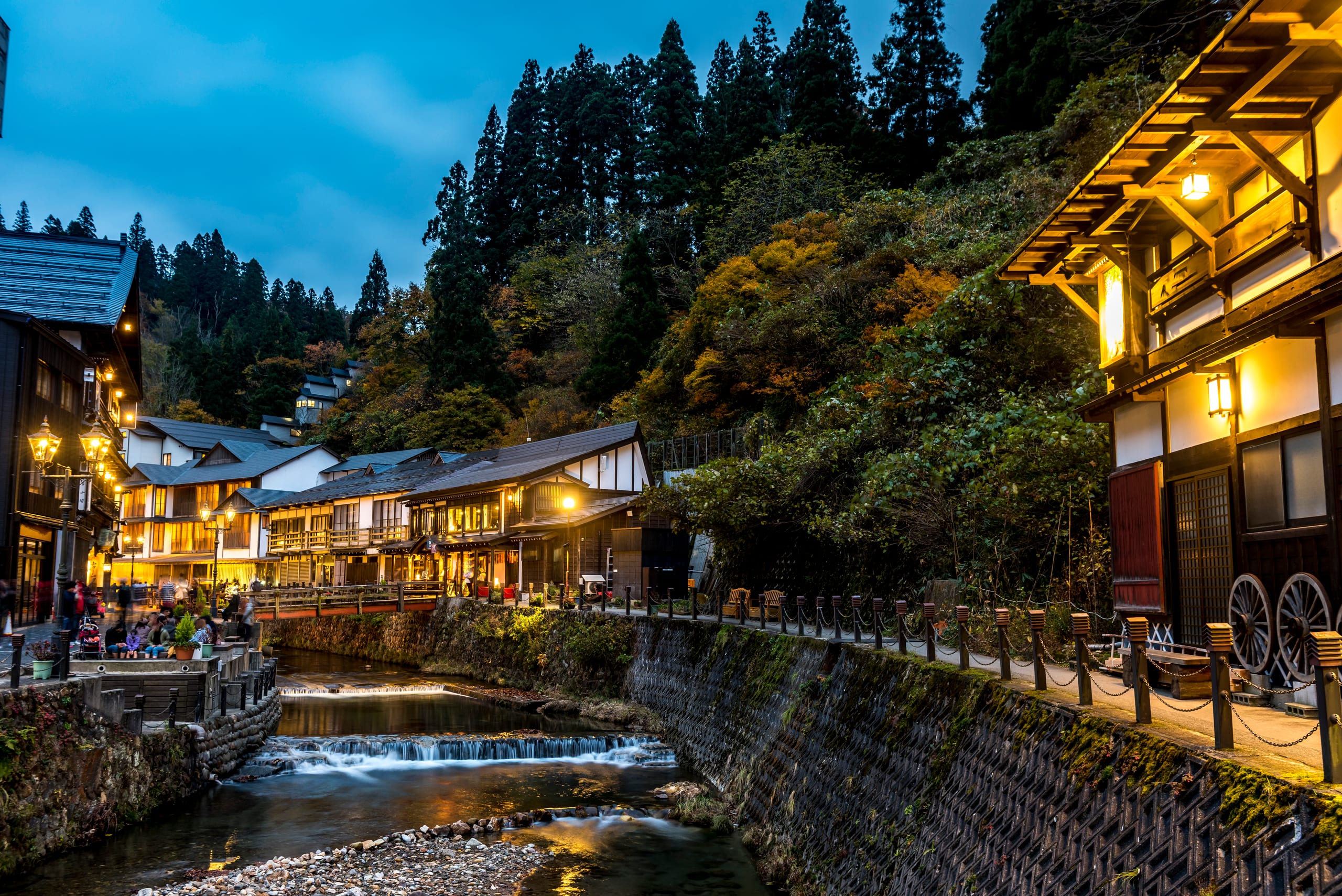 Ginzan Onsen's gas-lit street of wooden inns over the river at dusk