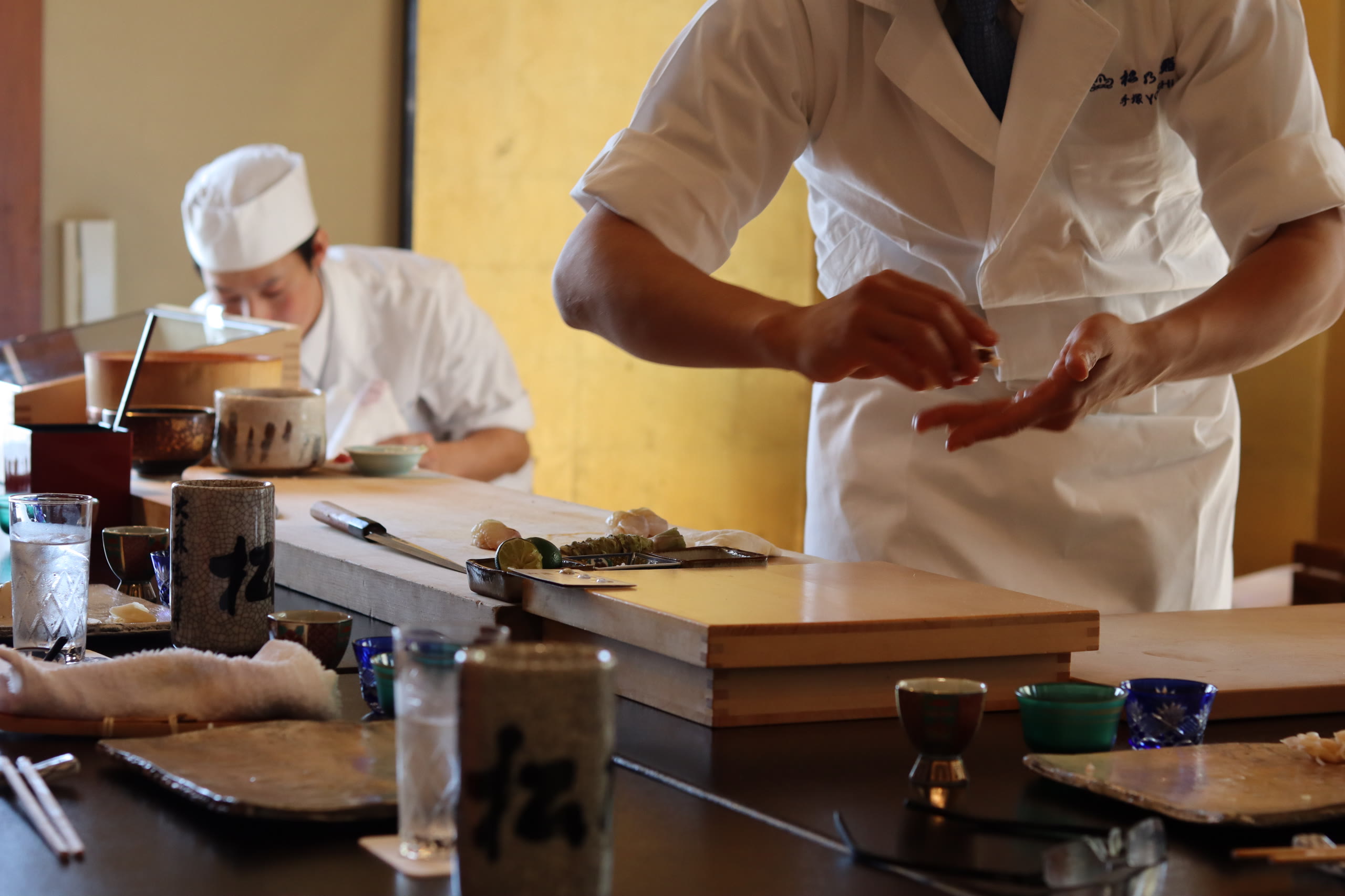 A sushi chef preparing nigiri at a counter in Hokkaido
