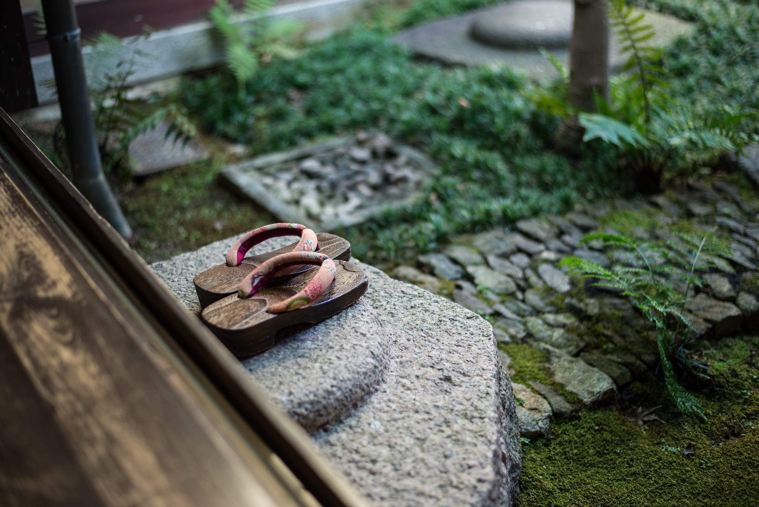 Wooden geta sandals resting on a stone lane