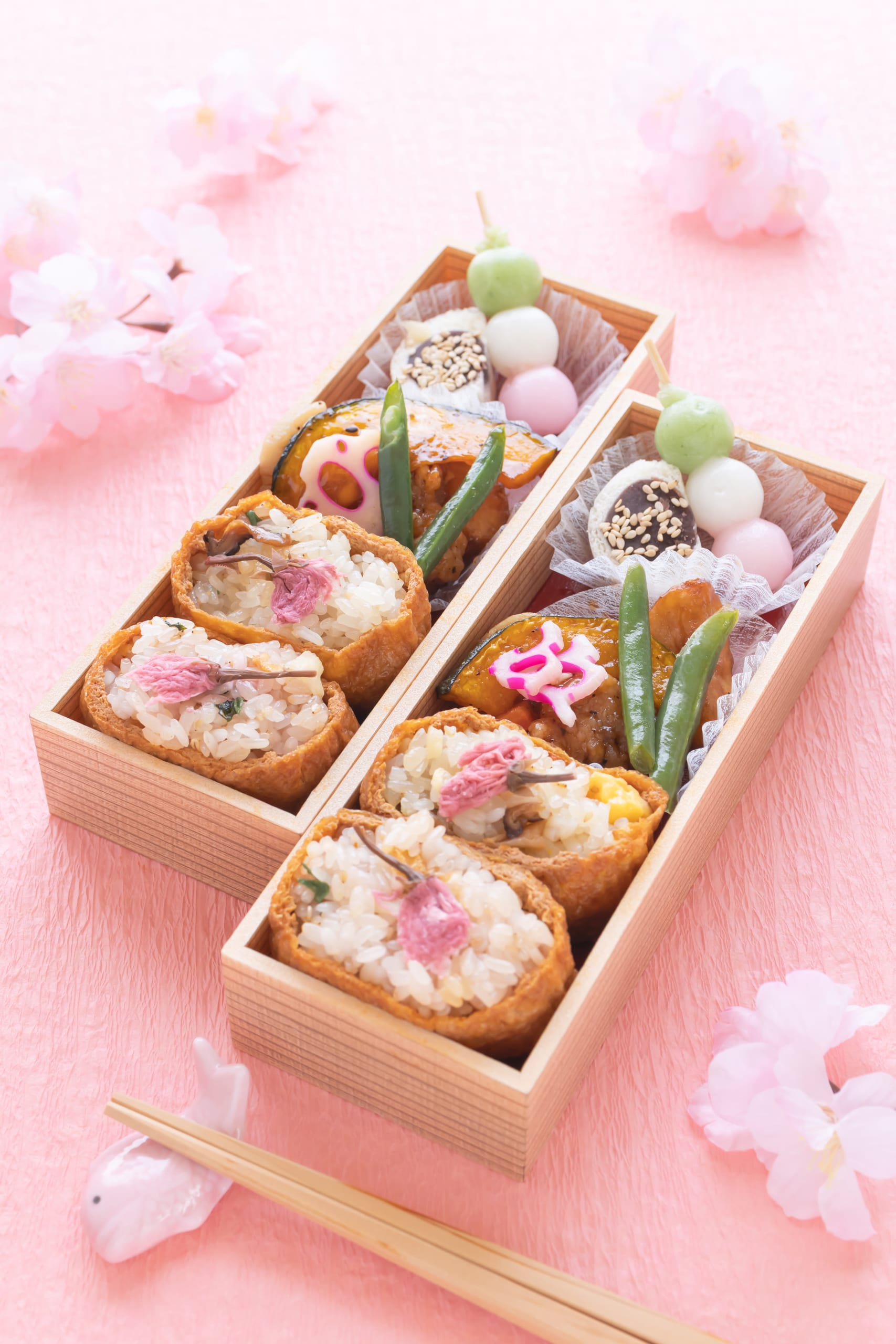 A hanami picnic laid on rugs beneath cherry blossom at the water's edge, Tokyo