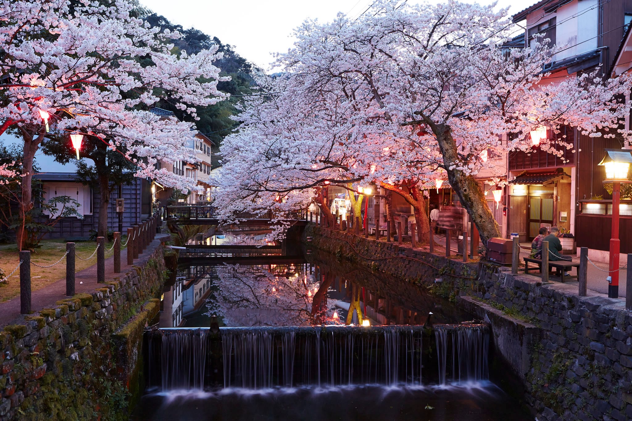 An open-air onsen bath at dusk in Kinosaki Onsen