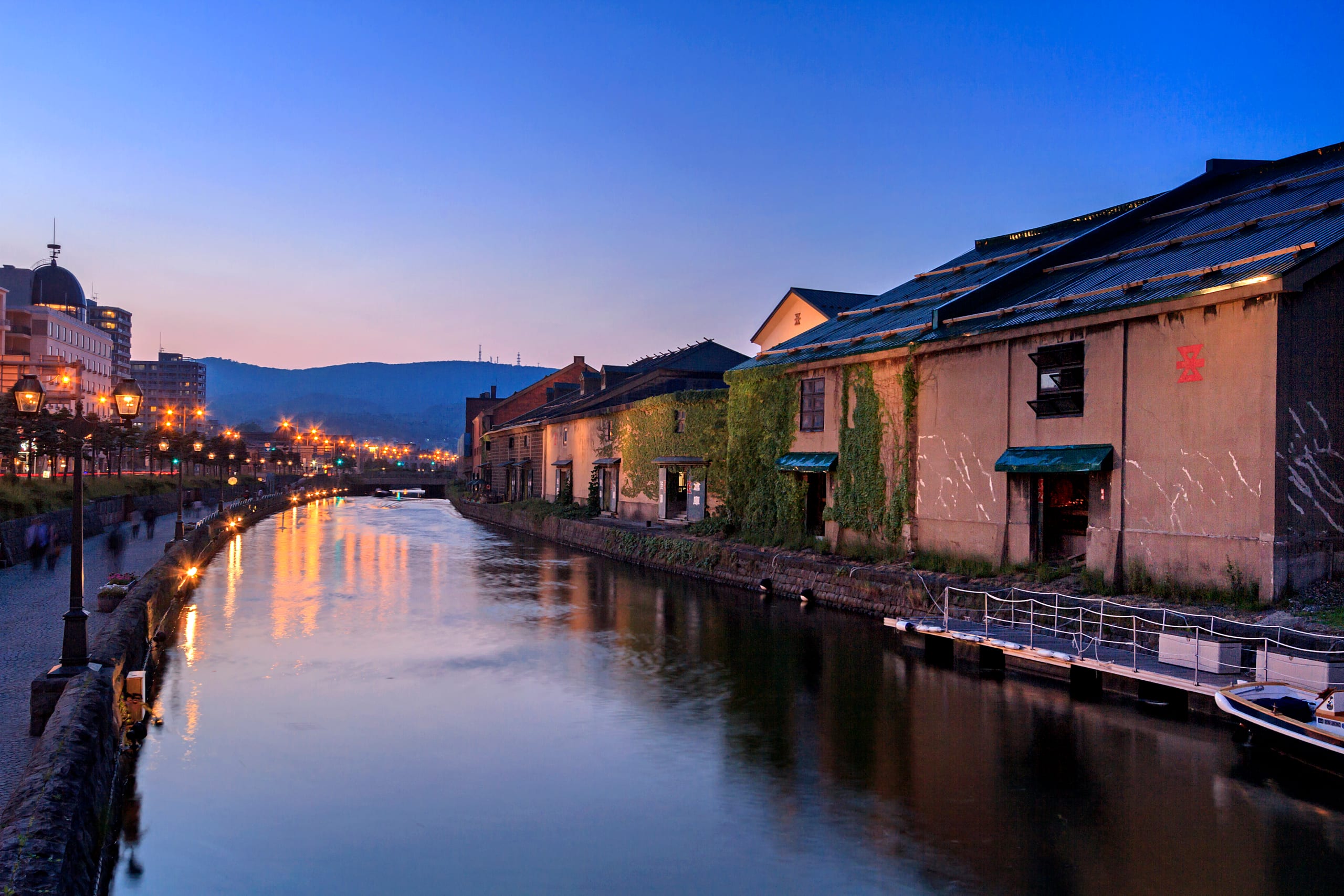 Otaru's stone warehouses lit along the canal at dusk