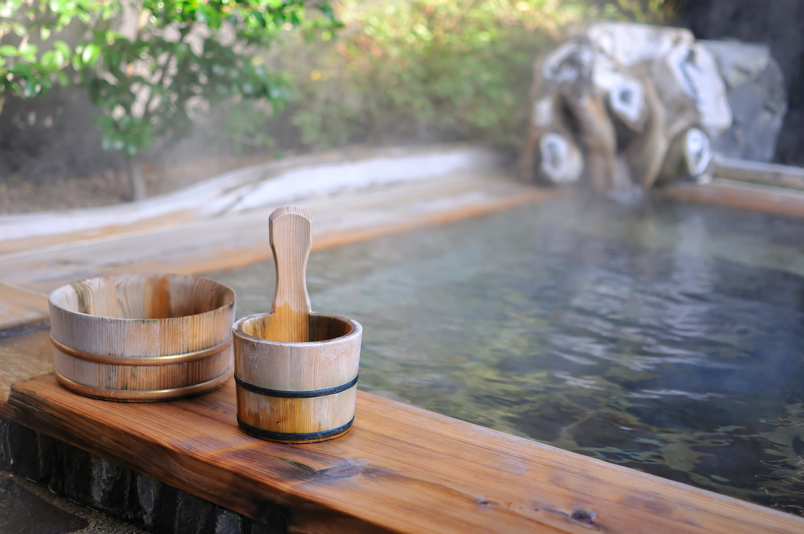 Wooden onsen buckets beside a bath, Hokkaido